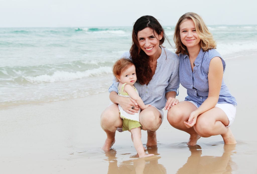 Two moms and baby at beach