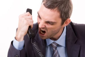 Man in suit screaming on office phone