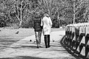 Couple walking in park together.