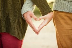 Couple making heart sign with hands