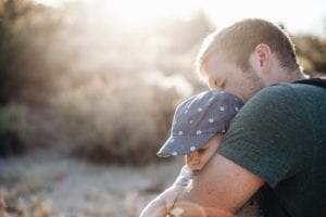 Man holding baby at sunset