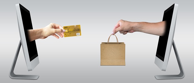 Hand holding credit card holding it out to hand with bag