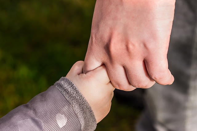 Baby holding parents finger