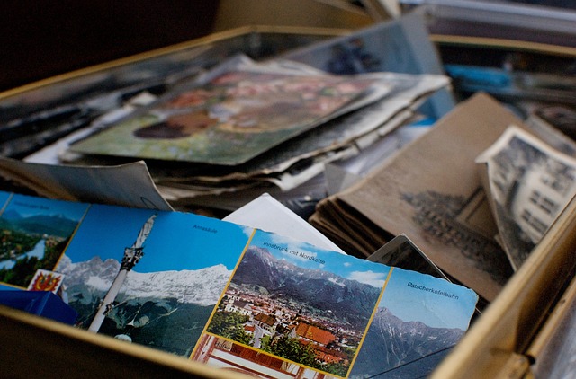 a close up picture of a box filled with photos, postcards and mementos.