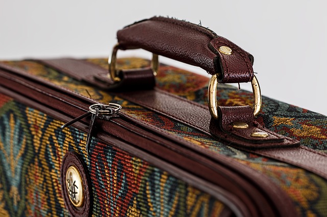 A close up of a well-used fabric suitcase