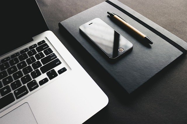 A close up of a laptop computer and a smart phone placed on a diary, showing that the owner is making efforts to stay on track