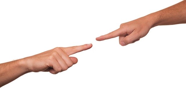 Two fingers pointing at each other as if to assign blame to one another.