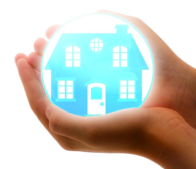 A picture of cupped hands holding a bubble with a picture of a home inside it.