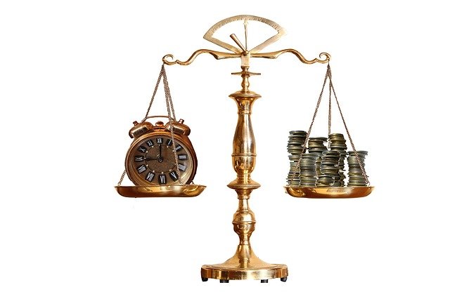 A scale containing a clock on one side and a stack of money on the other.