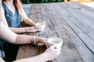 Close up of two young women having coffee at a table