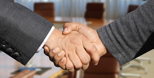 A close up of two people shaking hands.