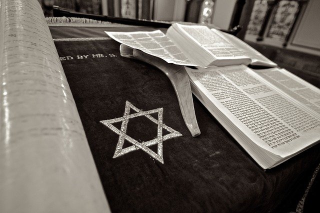 A star of David embroidered on a cloth, where a Torrah is lying open and ready to be read.