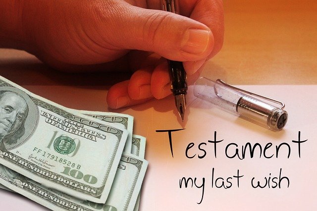 A close up of a ahand writing the eowrds "Testament: my last wish" next to several hundred dollar bills.