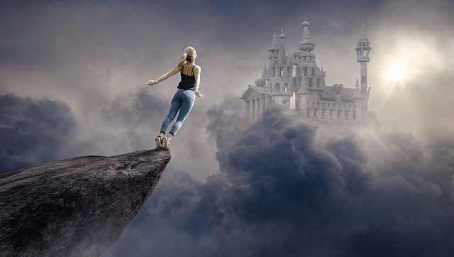 A woman flinging herself off a cliff edge towards a castle in the clouds, whihc is how it can feel leaving an abusive relationship.