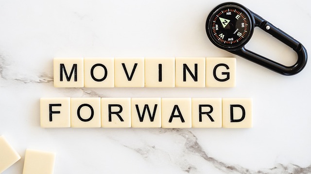 Scrabble tiles that say "moving forward' symbolizing the new life to come after a divorce.